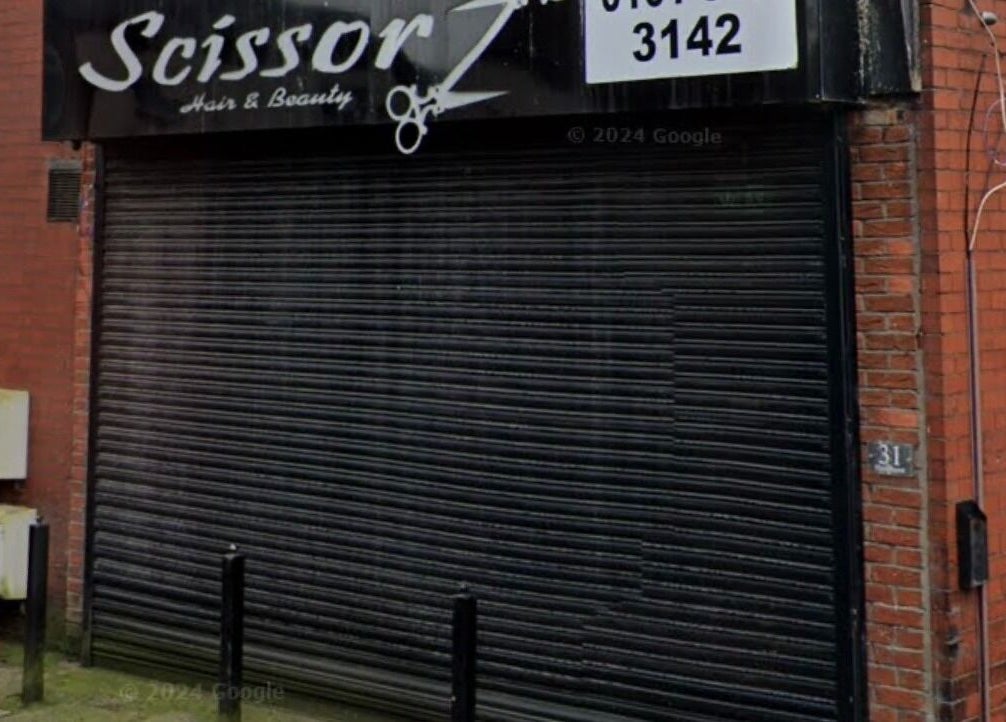 Street view of BARE FACED beauty venue in Worsley, England with closed metal shutters.