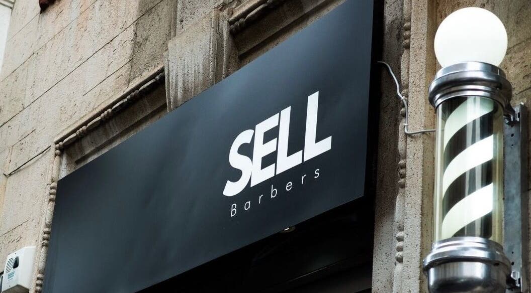 Insegna di Sell Barbers a Milano, Lombardia, IT con classico palo da barbiere a spirale.