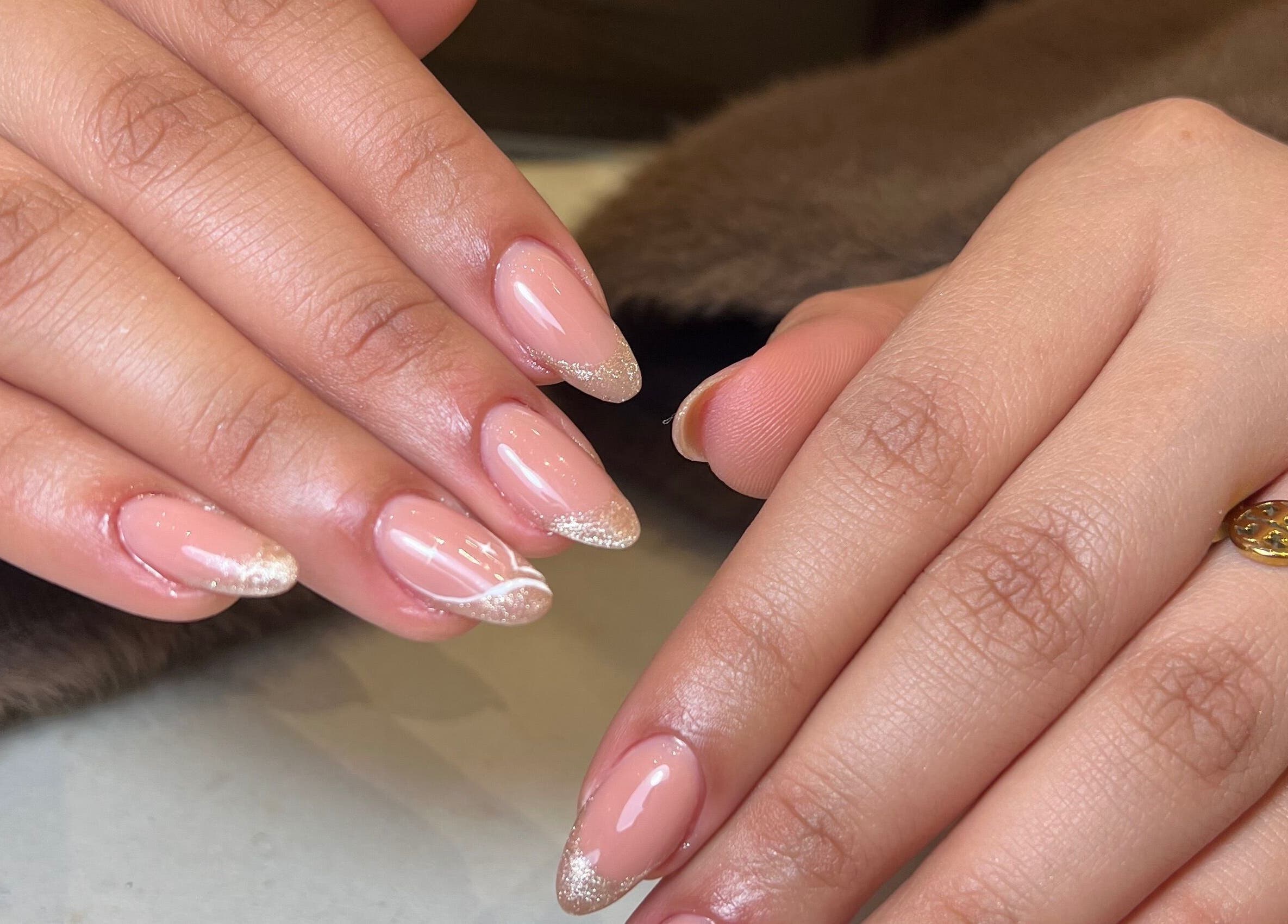 Elegant nails with pink polish and glitter tips at Aria Nail Bar and Spa, Al Khobar, Eastern Province, SA.