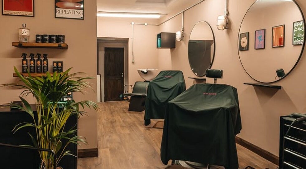 Cozy Studio120 interior showcasing modern salon setup in Bushey, England, GB with stylish mirrors and plant décor.