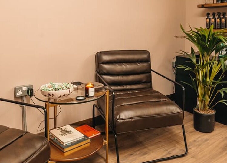 Cozy waiting area in Studio120, Bushey, England, GB with leather chairs and a potted plant.