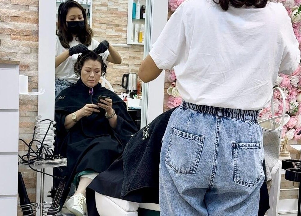 Stylist applying digital perm in Korean Digital Perm Salon, Dubai, Dubai, AE.