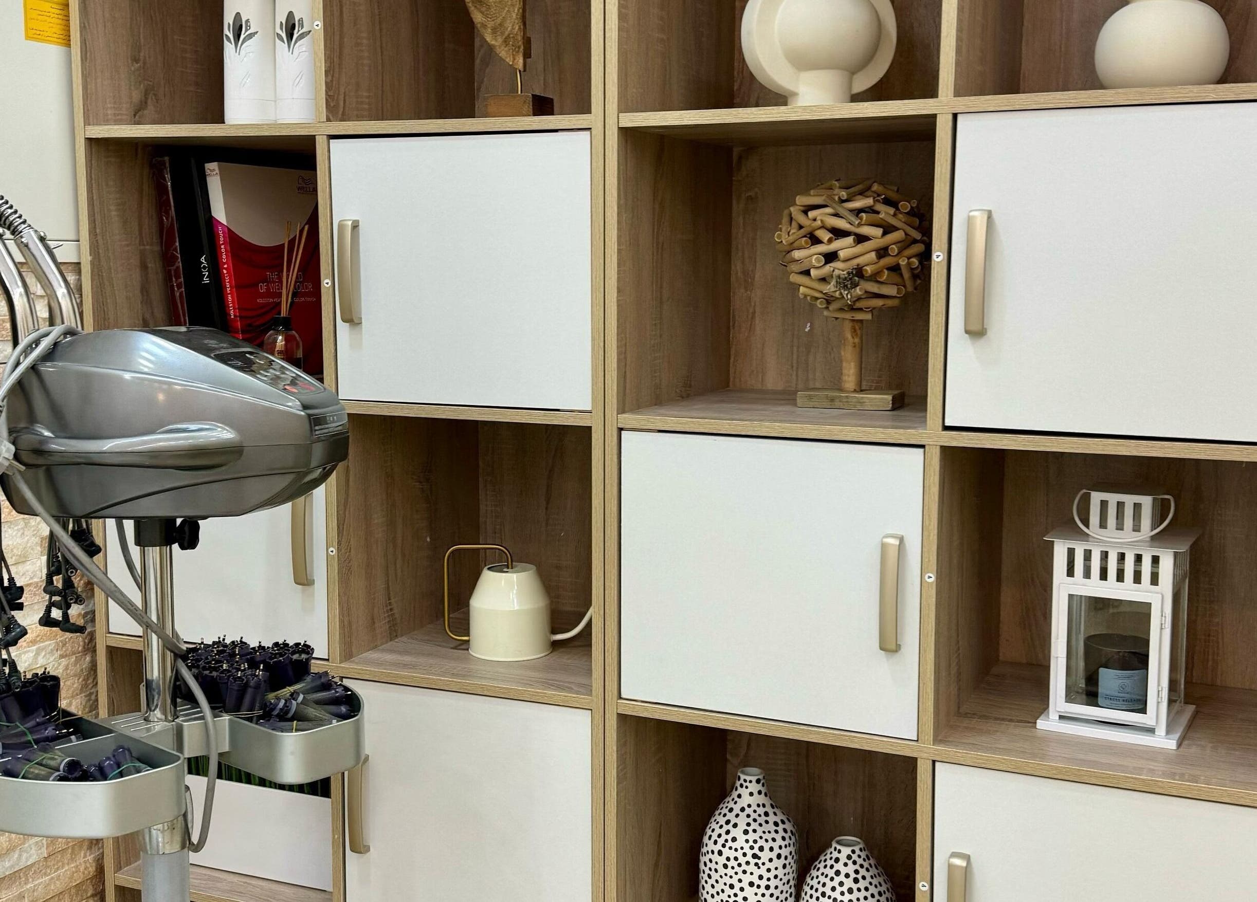 Perm equipment at Korean Digital Perm Salon in Dubai, Dubai, AE. Neatly organized on wooden shelves for efficient use.