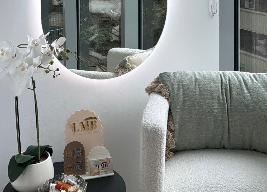Luxurious lounge area at La Maison de Beauté - St Leonards, St Leonards, New South Wales, AU, featuring a plush chair and decorative mirror.