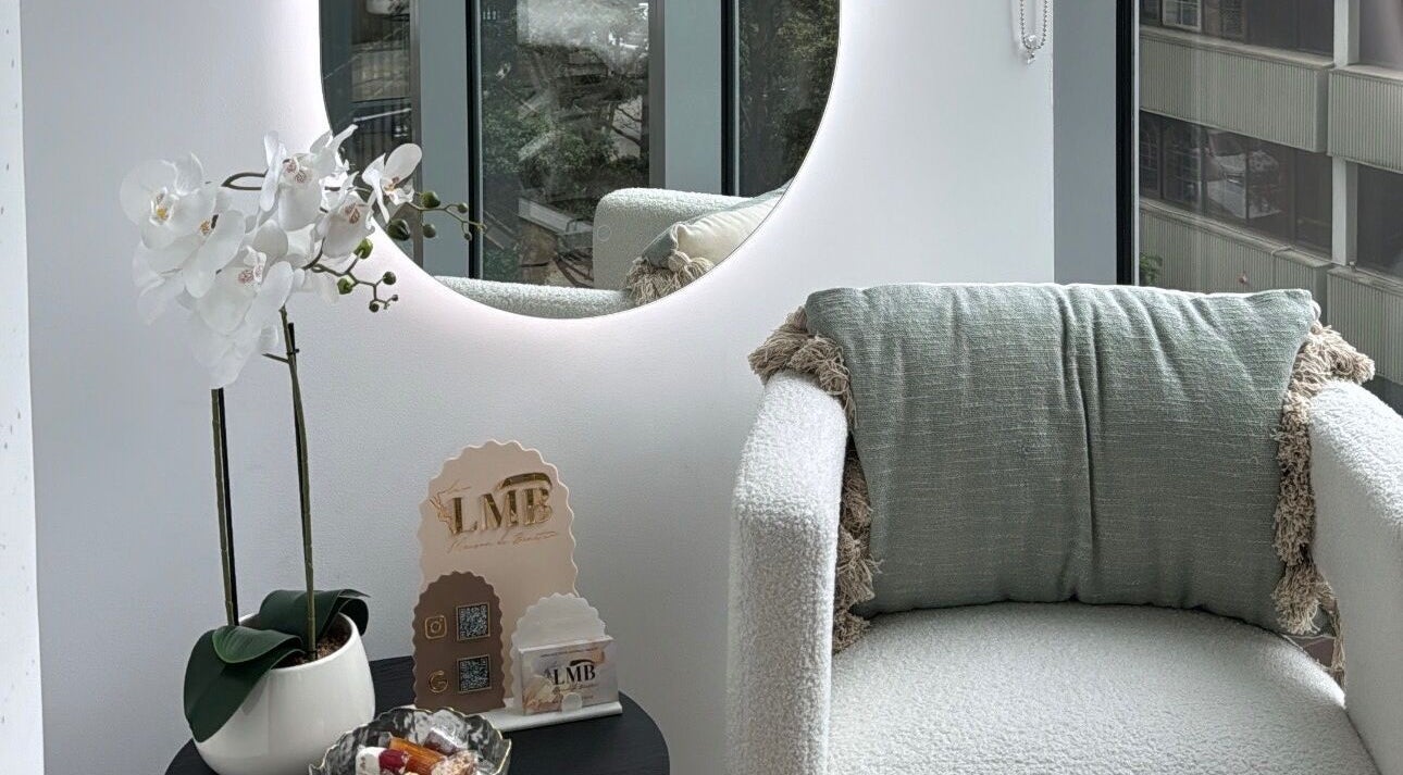 Luxurious lounge area at La Maison de Beauté - St Leonards, St Leonards, New South Wales, AU, featuring a plush chair and decorative mirror.