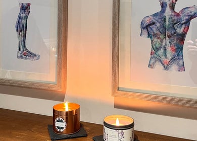 Cozy candles beneath anatomical art at Sports Massage with Paula, Llandudno Junction, Wales, GB.