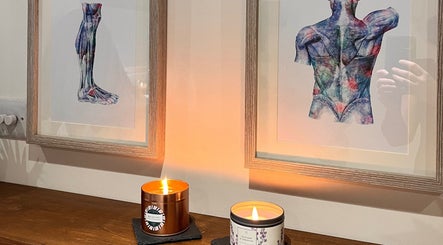 Cozy candles beneath anatomical art at Sports Massage with Paula, Llandudno Junction, Wales, GB.