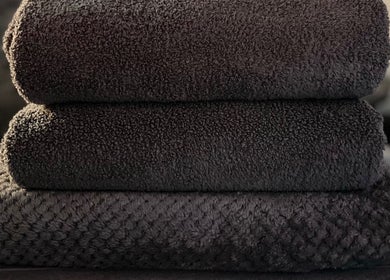 Stack of luxurious black towels at Sports Massage with Paula, Llandudno Junction, Wales, GB.