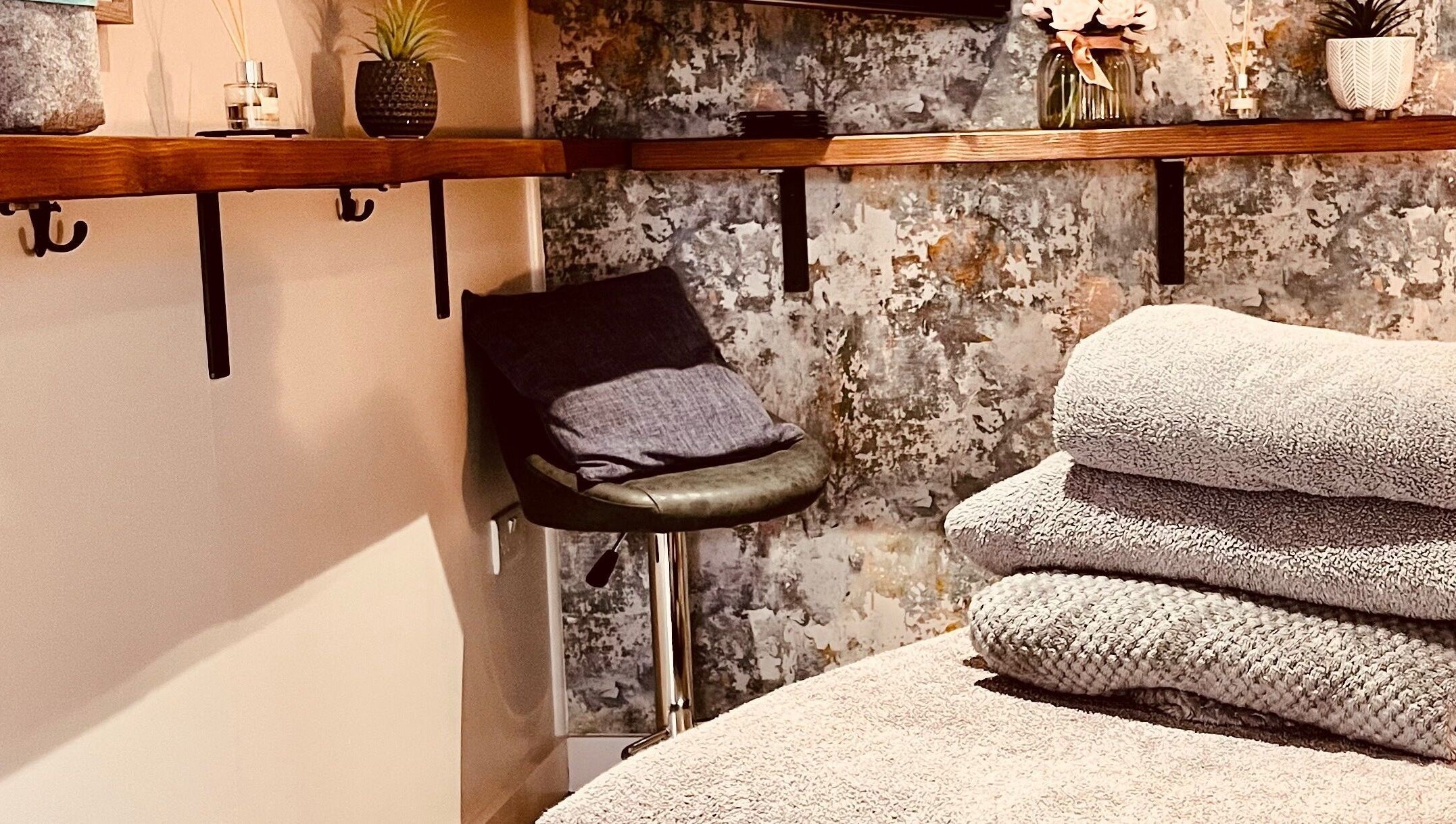 Relaxing massage room at Sports Massage with Paula in Llandudno Junction, Wales, GB with soft towels and plants.