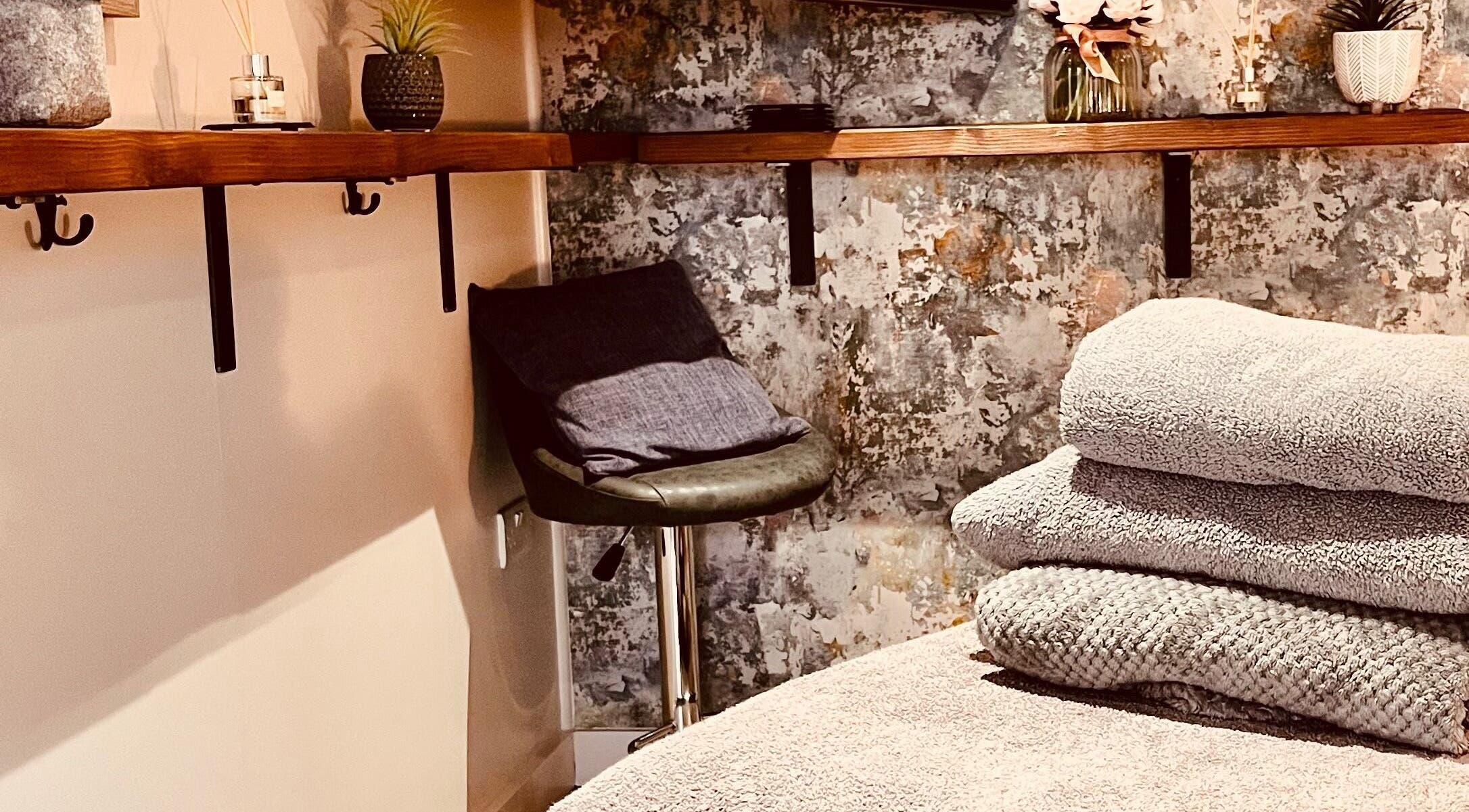 Relaxing massage room at Sports Massage with Paula in Llandudno Junction, Wales, GB with soft towels and plants.