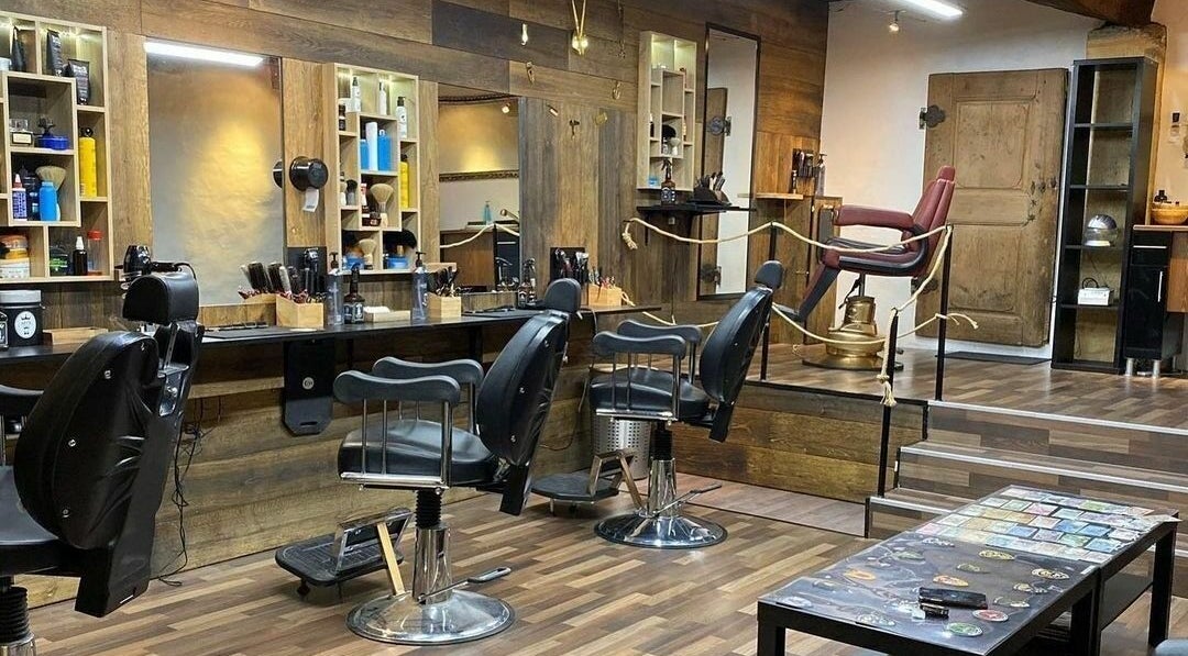 Innenansicht von Artis Barber Shop, Murten, Freiburg, CH mit stilvollem Holzdekor und modernen Friseurstühlen.