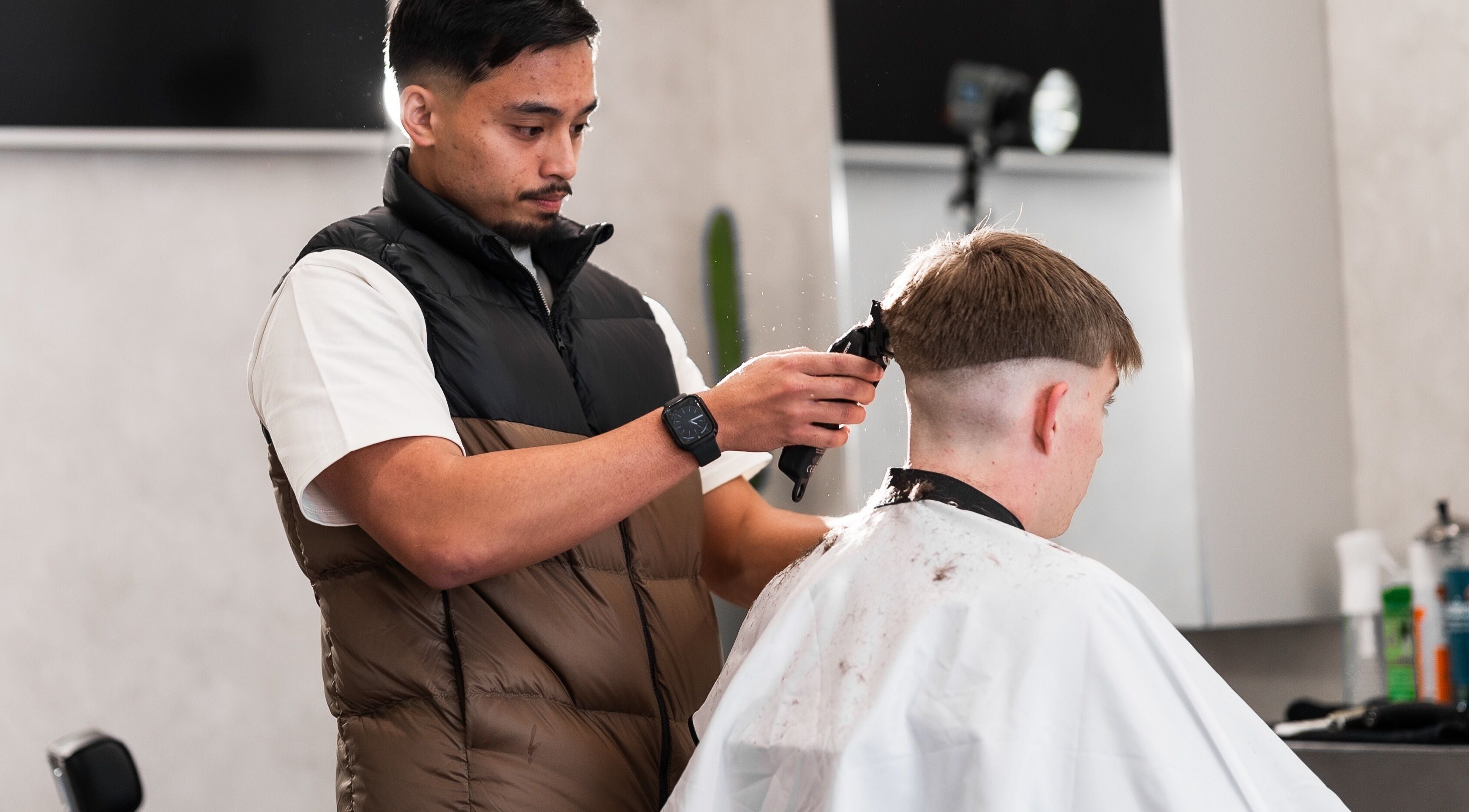A barber expertly trims a client's hair at South Side Studios, Melbourne, Victoria, AU.