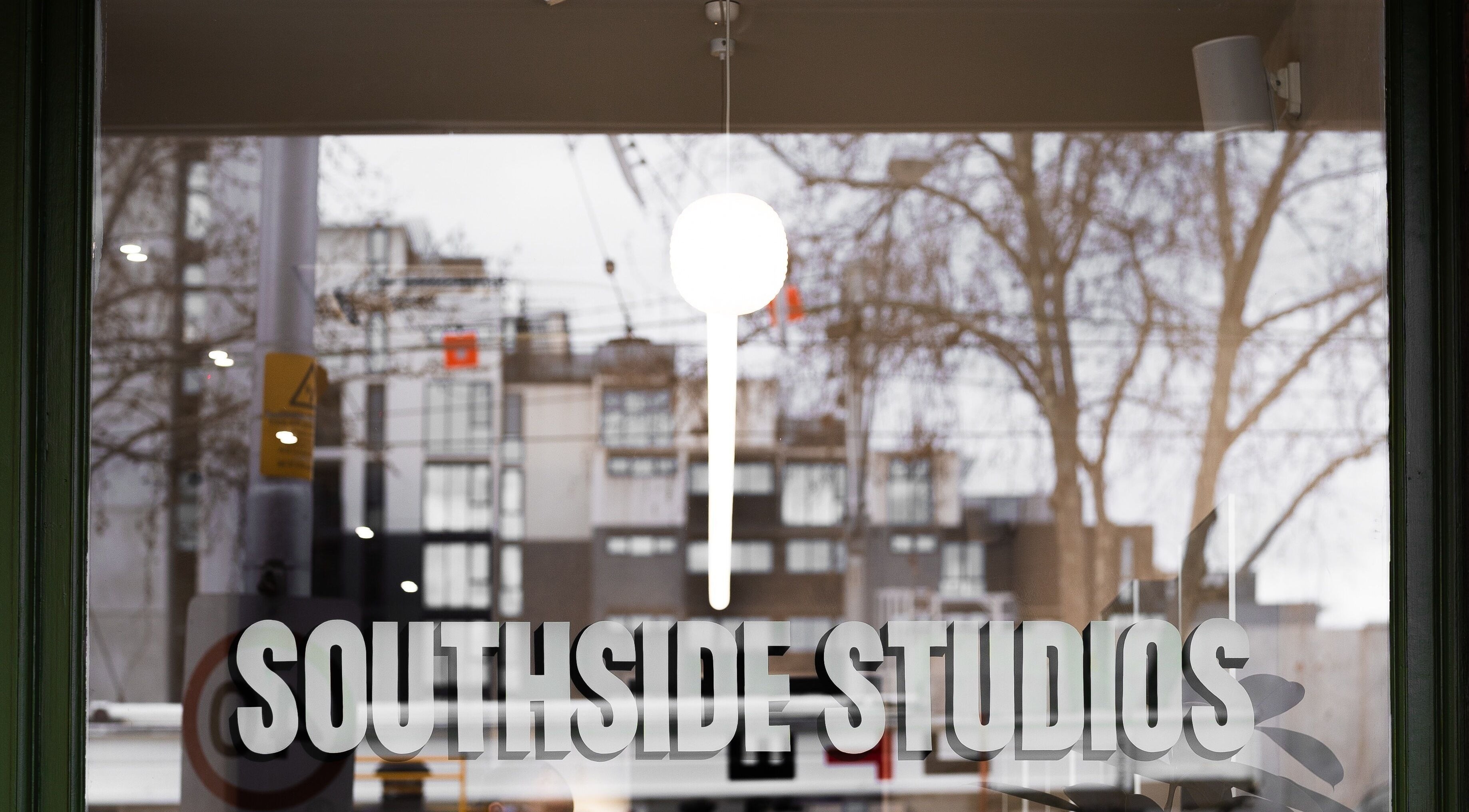 Entrance of South Side Studios, Melbourne, Victoria, AU with clear window signage and street view.