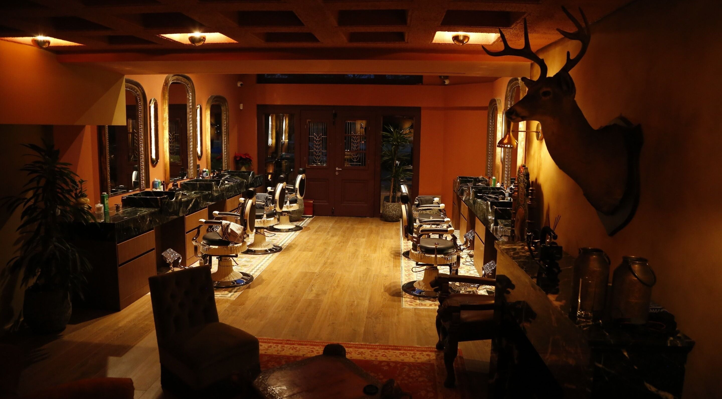 Warm, inviting interior of Hemingway Gentlemen’s Guild, Iraklio Athens, GR, featuring classic barber chairs.