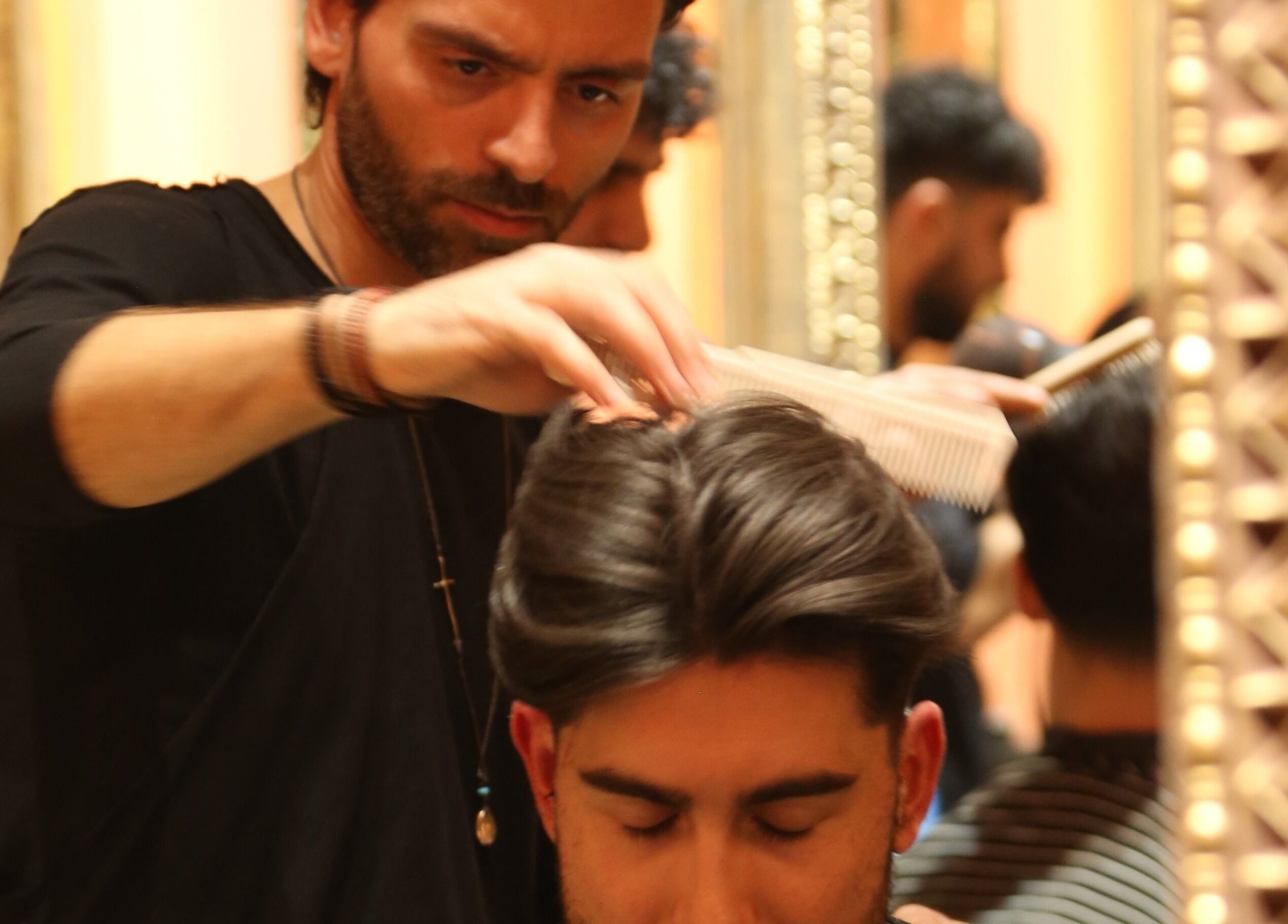 Expert stylist at Hemingway Gentlemen’s Guild in Iraklio, Athens, GR grooming a client's hair.