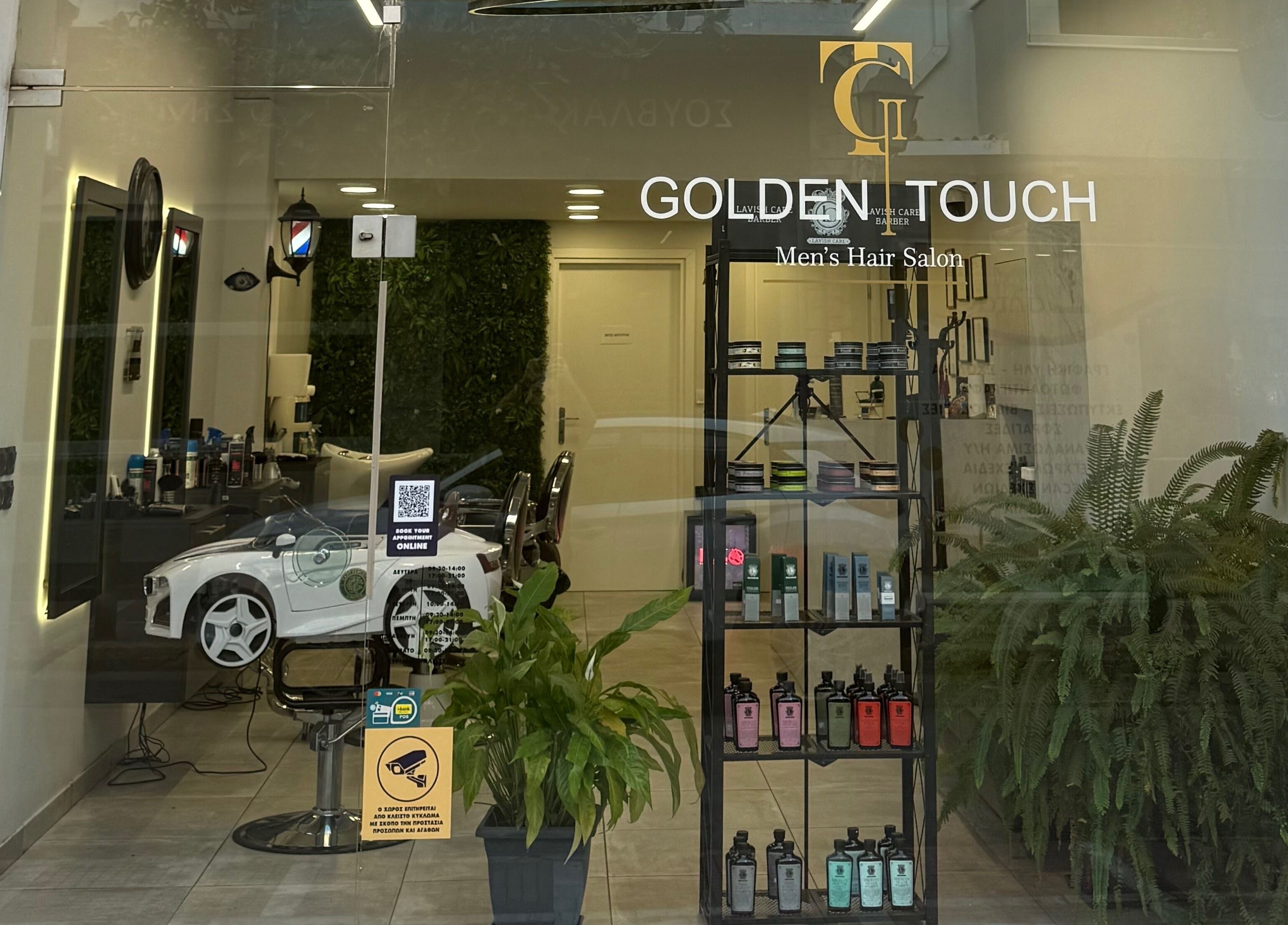 Κομψή πρόσοψη του Golden Touch MensHair στα Μέγαρα, GR με σύγχρονη διακόσμηση και φροντισμένα φυτά.