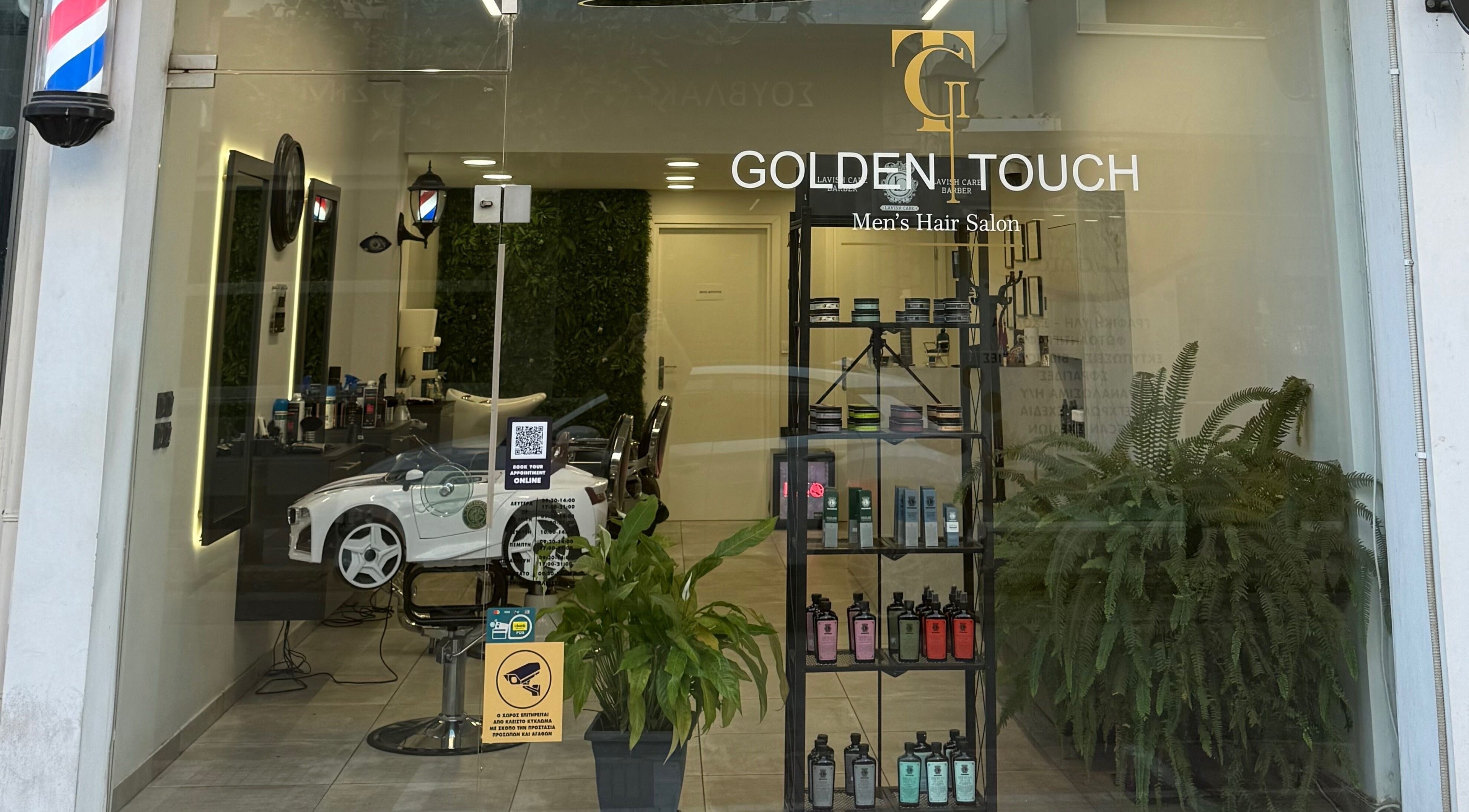 Κομψή πρόσοψη του Golden Touch MensHair στα Μέγαρα, GR με σύγχρονη διακόσμηση και φροντισμένα φυτά.