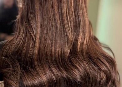Shiny brown wavy hair styled at Hair Lounge With Ferne in Ash, England, GB.