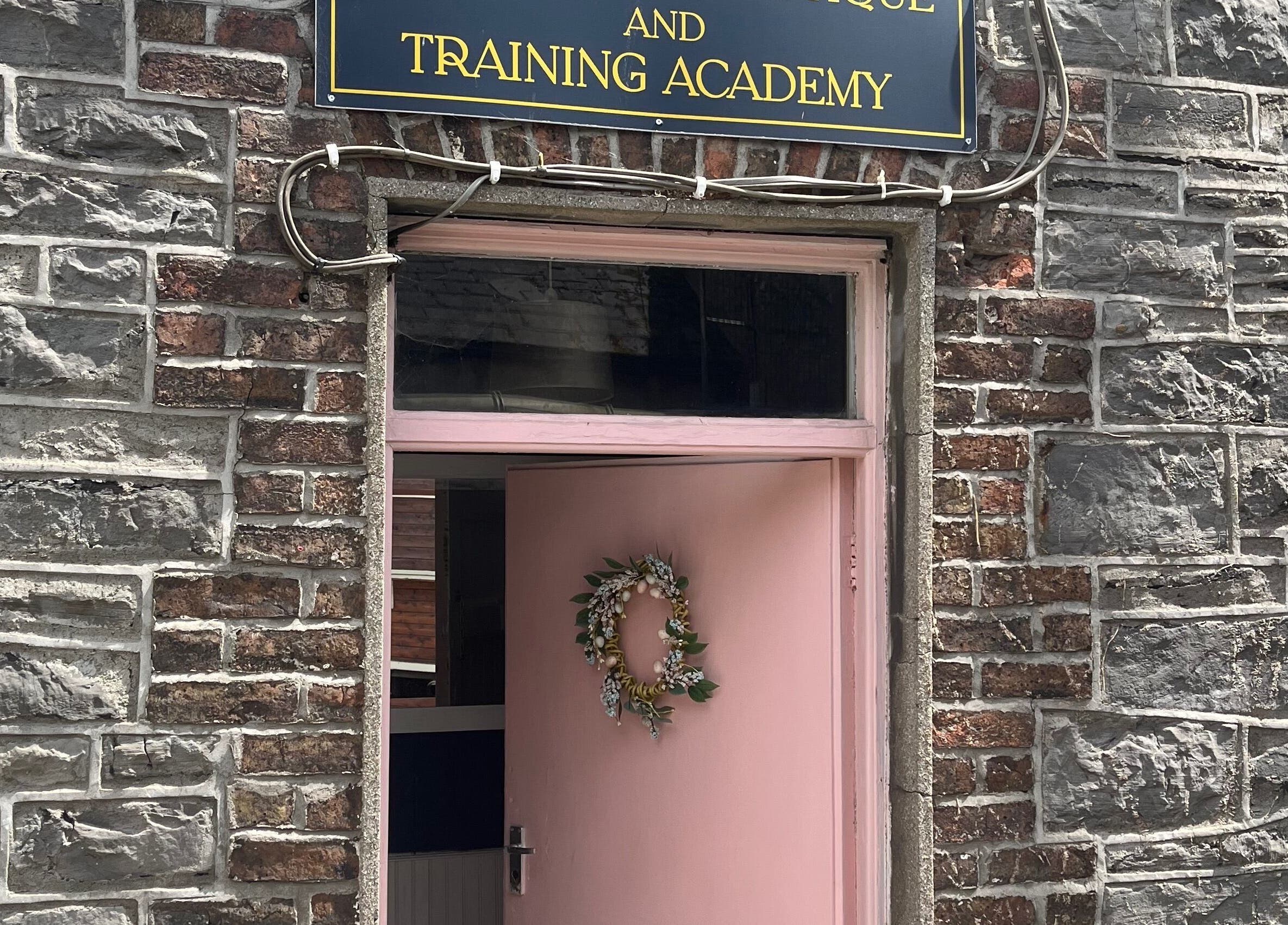 Entrance of Leigh B Makeup & Brows Artist in Drogheda, County Louth, IE, with a stylish pink door and wreath.