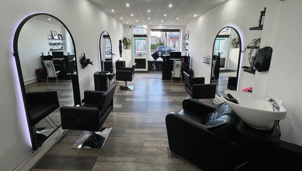 Modern interior of S & L Hair Studio in Newtongrange, Scotland featuring sleek black chairs and mirrors.