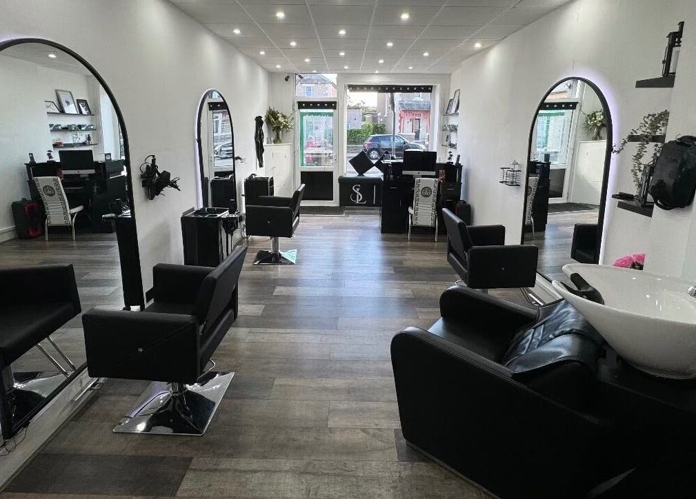 Modern interior of S & L Hair Studio in Newtongrange, Scotland featuring sleek black chairs and mirrors.