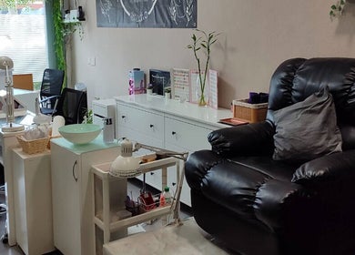 Interior acogedor de Yhara Nails Studio, Madrid, con sillón de masaje y estación de manicura.