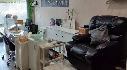 Interior acogedor de Yhara Nails Studio, Madrid, con sillón de masaje y estación de manicura.