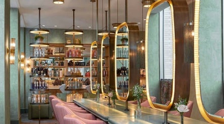 Interior elegante de Nails_byNar en Londres, Inglaterra, GB, con espejos dorados y sillas rosas.