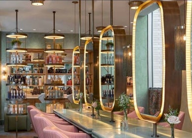 Interior chic de Nails_byNar en Londres, Inglaterra, con espejos dorados y sillas rosadas.