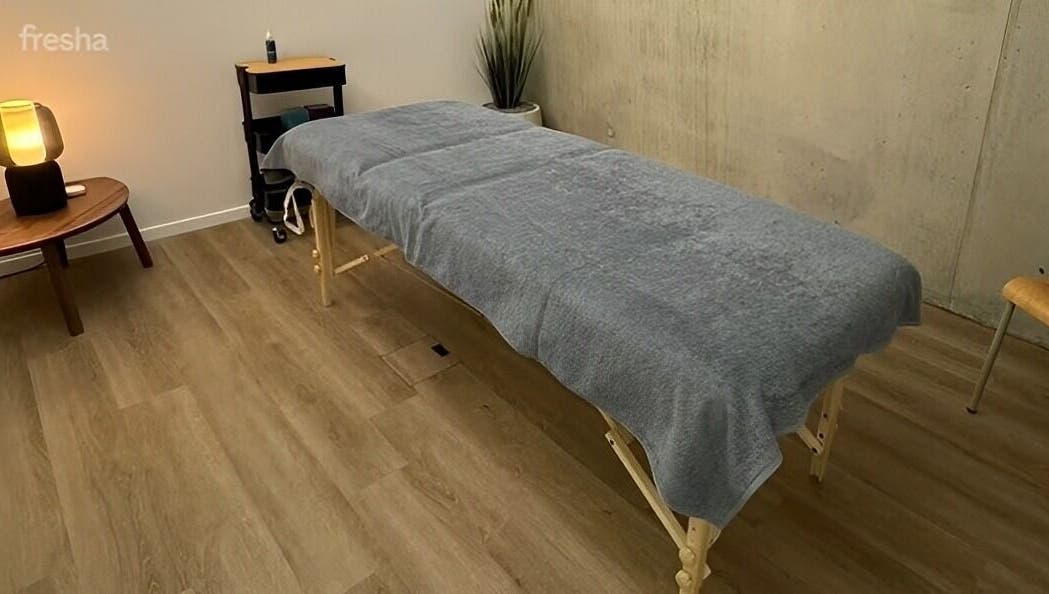 Salle de massage élégante à L'instant Colibri, Petit-lancy, Genève, CH, avec table de massage et lumière douce.