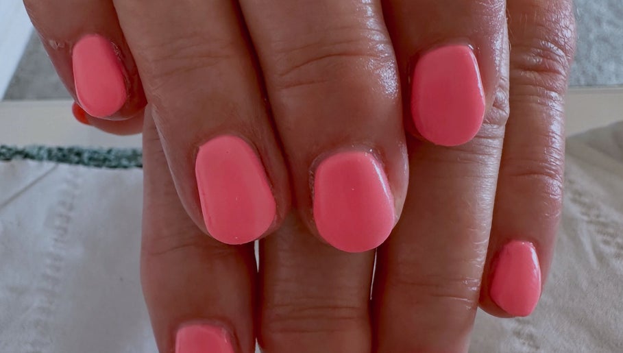 Vibrant coral nails at Sun Kissed Nail & Wax Studio, Thurso, Scotland, GB. Perfect for a chic, polished look.