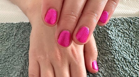 Bright pink nails at Sun Kissed Nail & Wax Studio, Thurso, Scotland, GB on a soft textile background.