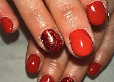 Close-up of vibrant red nails with a glitter accent at Sun Kissed Nail & Wax Studio, Thurso, Scotland, GB.