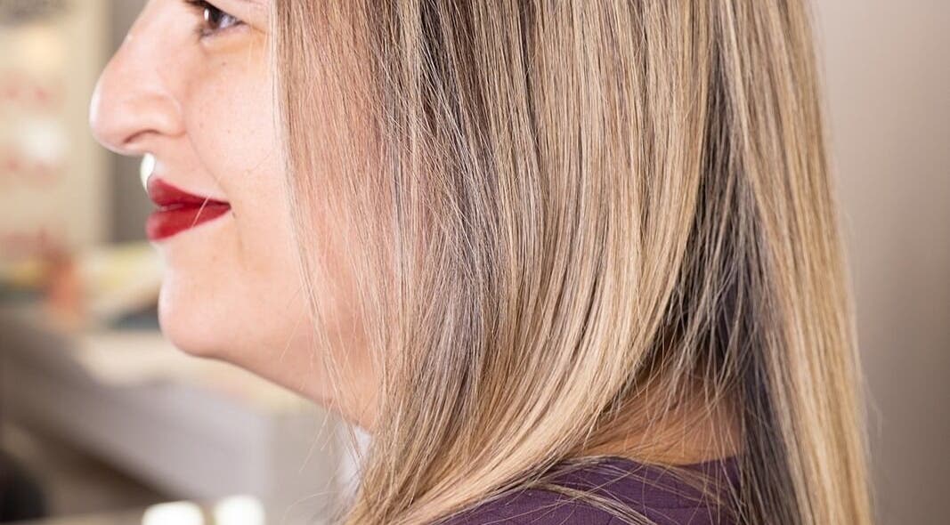 Profile of a woman with sleek blond hair at Hairlux by Naomi, Ħal Safi, MT.