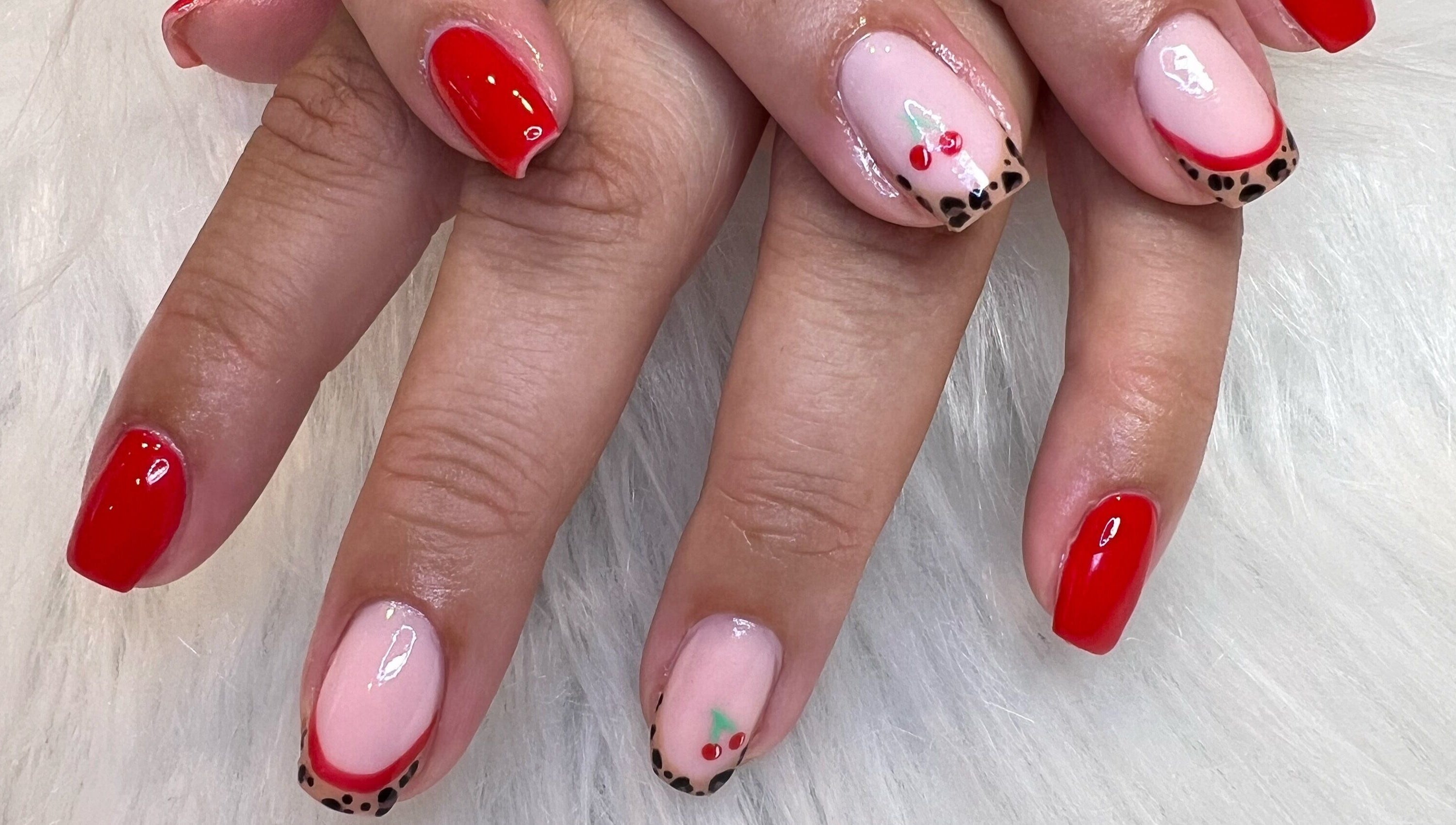 Red and cherry nail art at The Glitter Garage, Halifax, England, GB. Vibrant and stylish design on a white background.