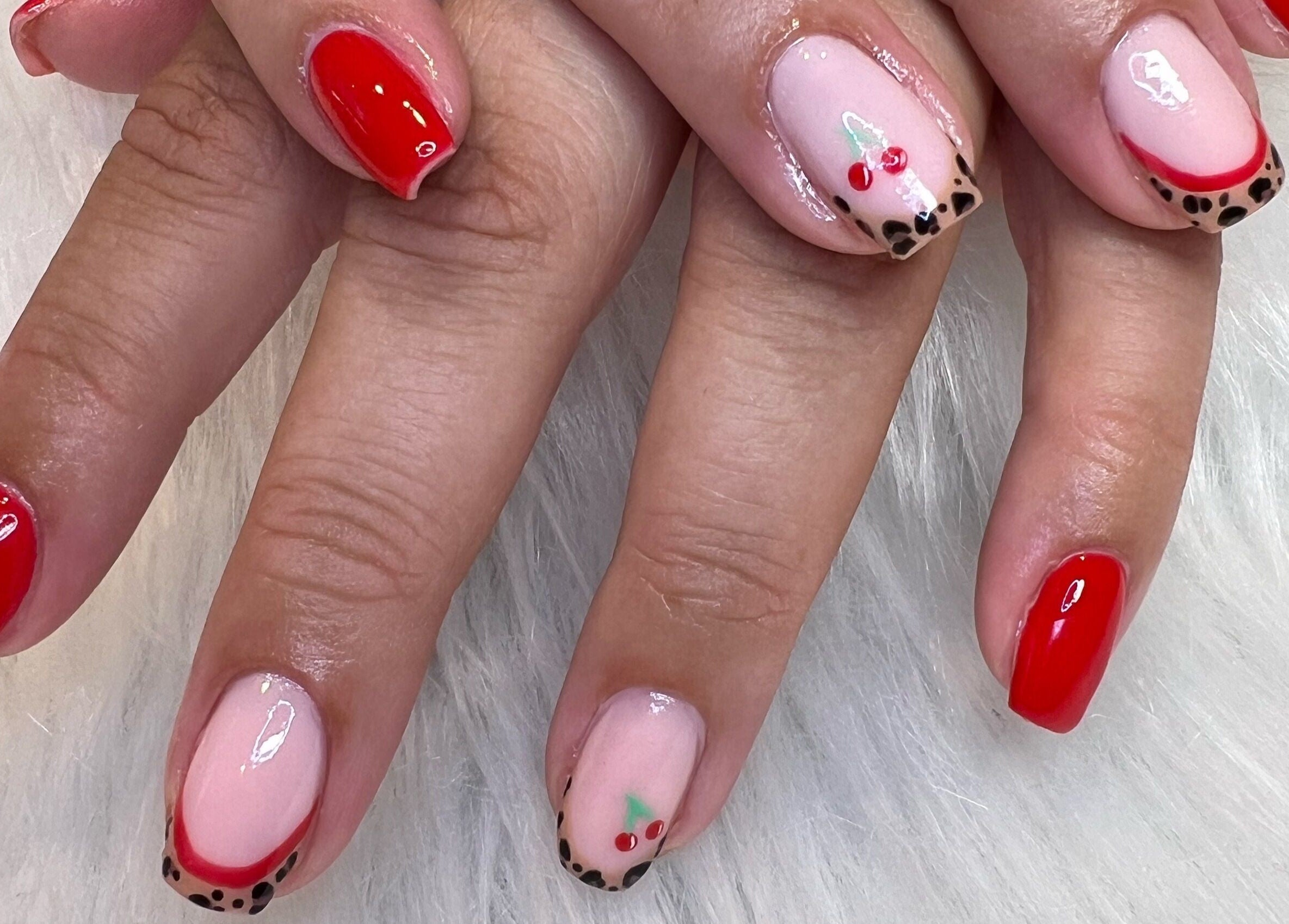Red and cherry nail art at The Glitter Garage, Halifax, England, GB. Vibrant and stylish design on a white background.