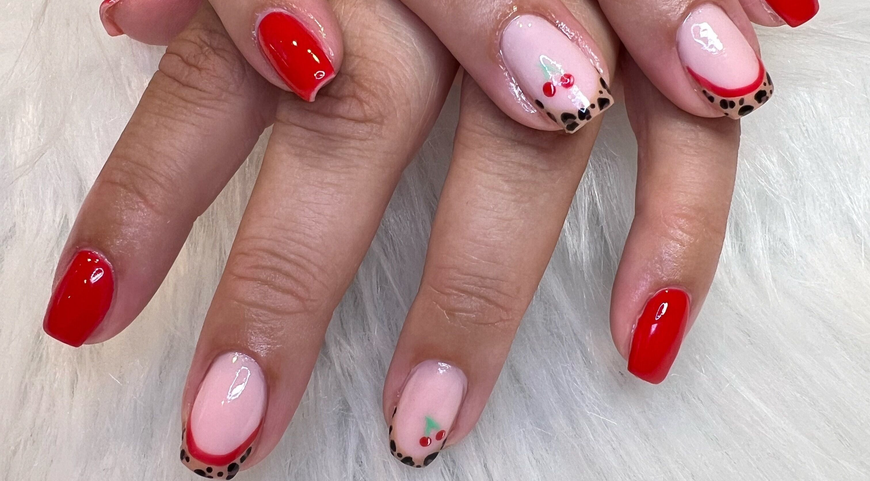 Red and cherry nail art at The Glitter Garage, Halifax, England, GB. Vibrant and stylish design on a white background.