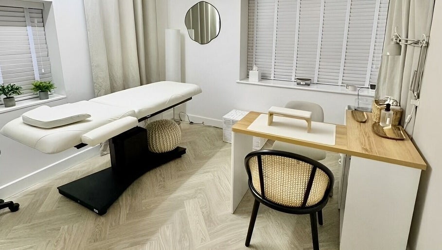 Cozy treatment room at The Lookery Beauty Room, Milton Keynes, England, GB, featuring a massage bed and nail station.