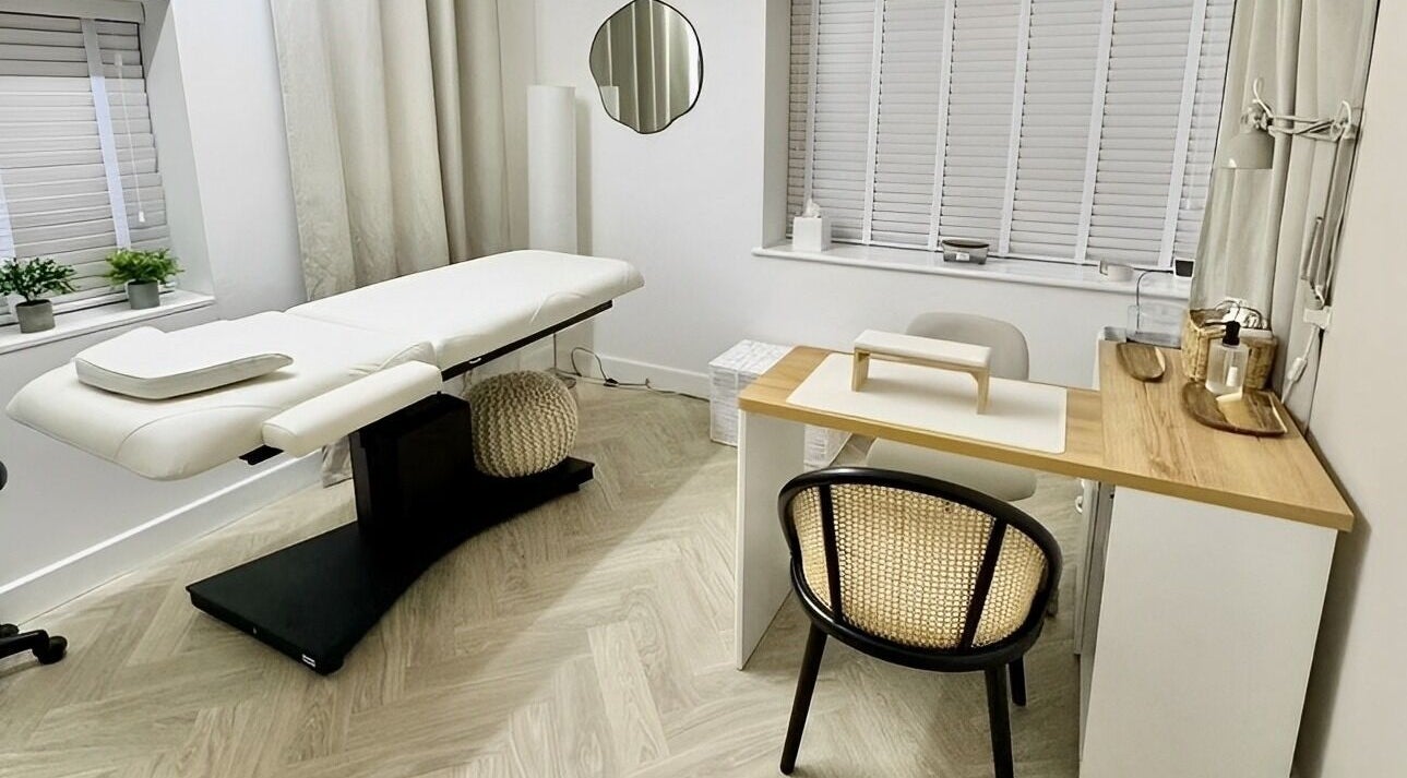 Cozy treatment room at The Lookery Beauty Room, Milton Keynes, England, GB, featuring a massage bed and nail station.