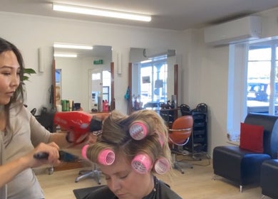Hair By Kisha at Wairau HairDesign, Auckland, Auckland, NZ: Expert stylist working on a client's hair with rollers.