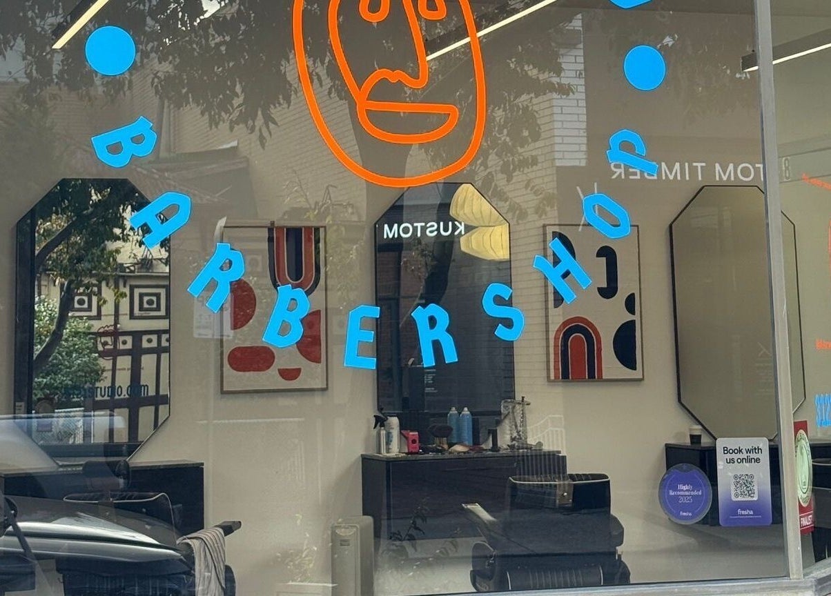 Exterior of 3121 Studio, a trendy barbershop in Melbourne, Victoria, AU with colorful window signage.