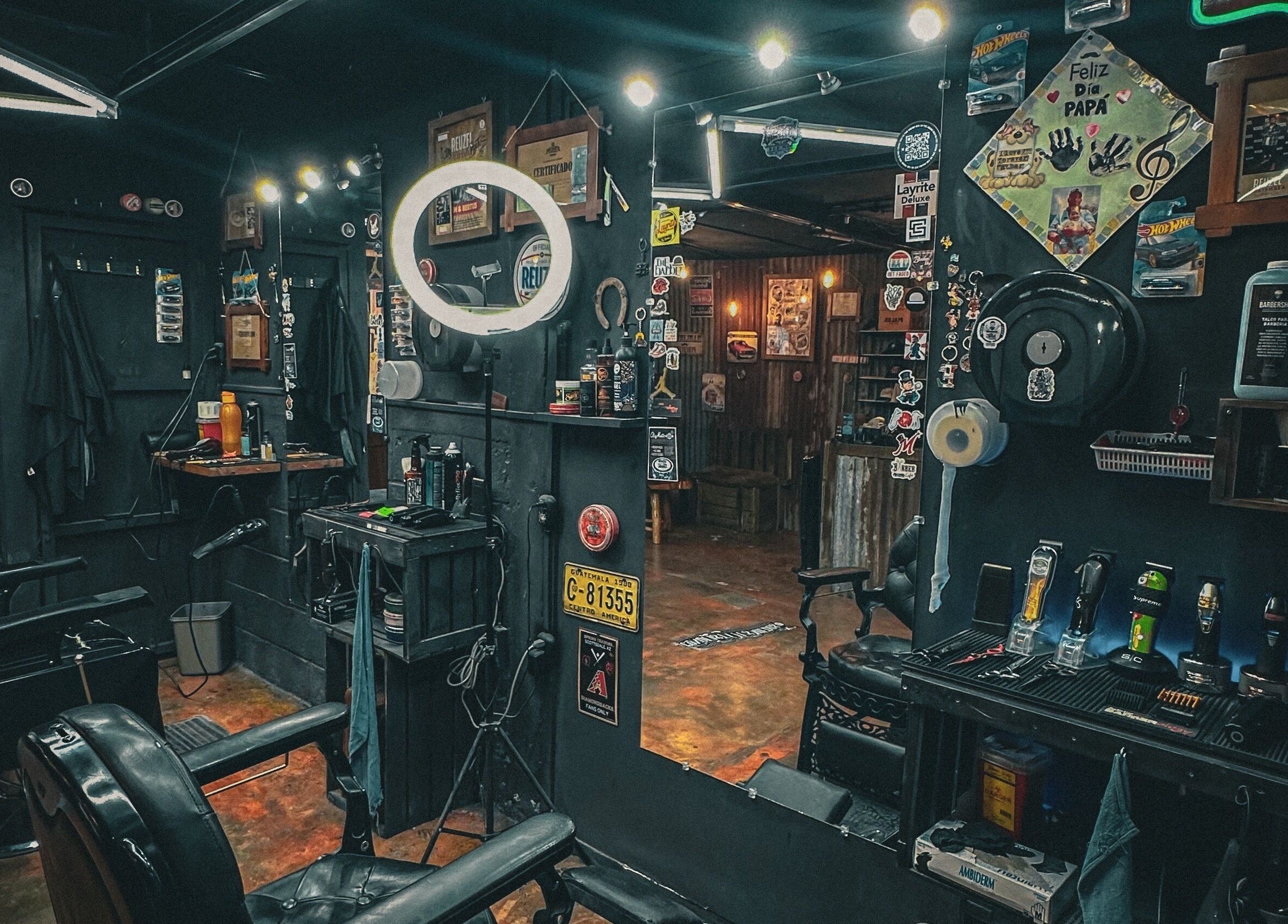 Interior de The Barber en Tecpán, Chimaltenango, GT, mostrando sillas y un espejo iluminado.
