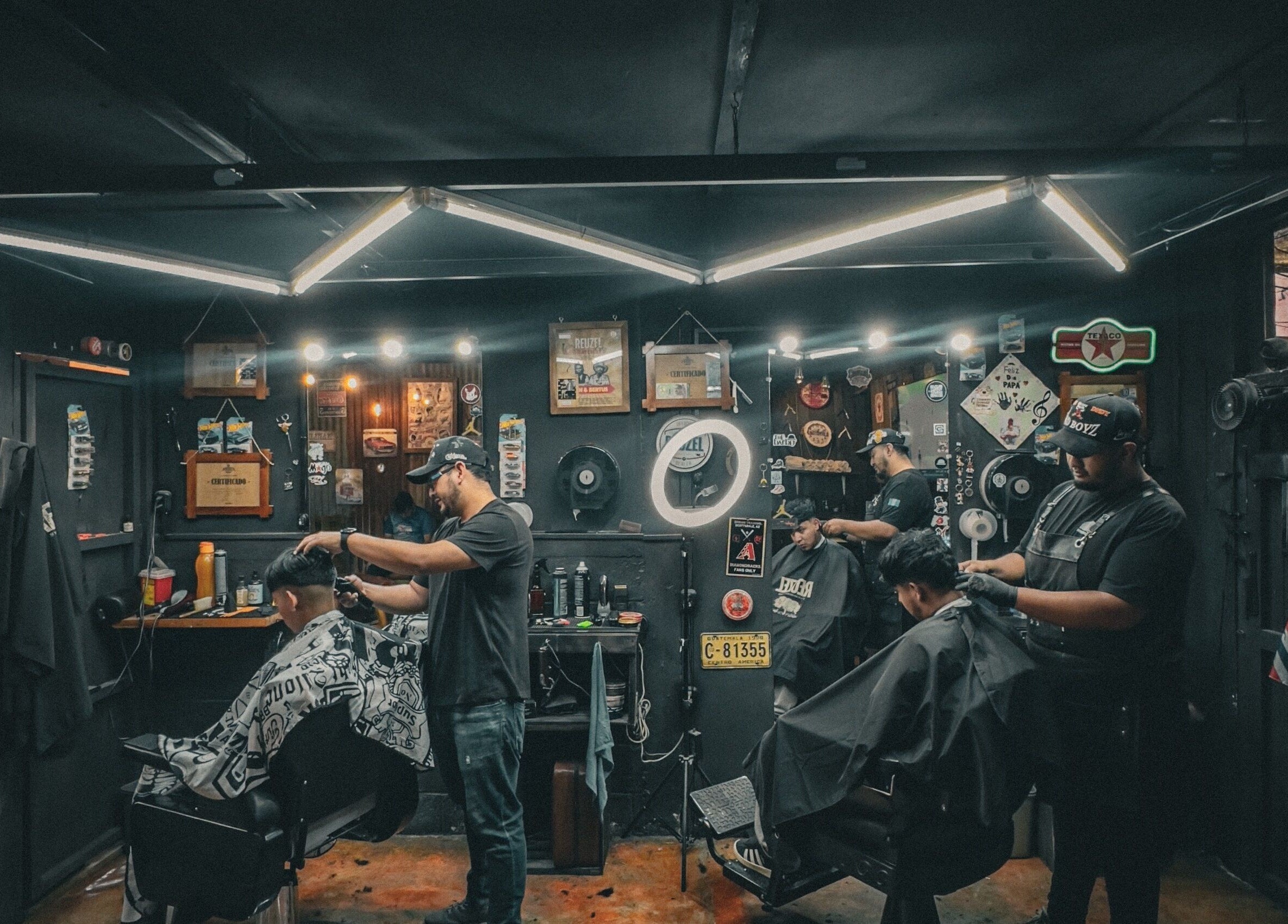 Interior de The Barber en Tecpán, Chimaltenango, GT con barberos trabajando.