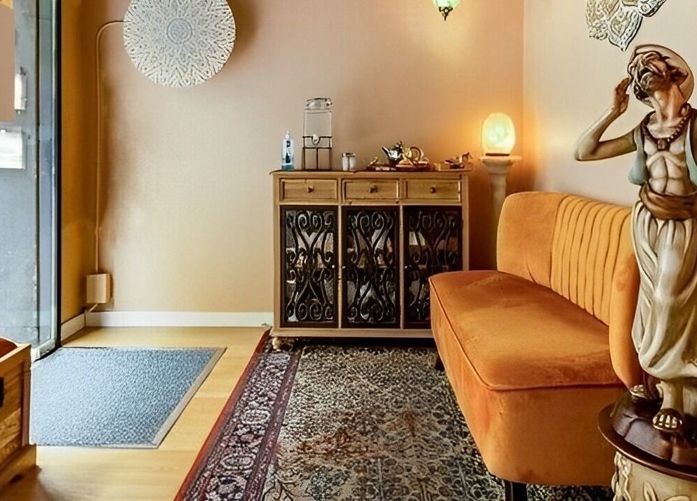 Sala de espera elegante en Relax and Time, Barcelona, Catalunya, ES, con sofá naranja y decoración artística.