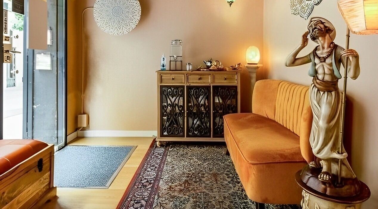 Sala de espera elegante en Relax and Time, Barcelona, Catalunya, ES, con sofá naranja y decoración artística.