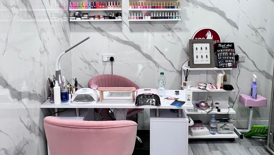 Modern nail station at Star Nail Riddrie in Glasgow, Scotland, GB, featuring elegant pink decor and nail polish display.