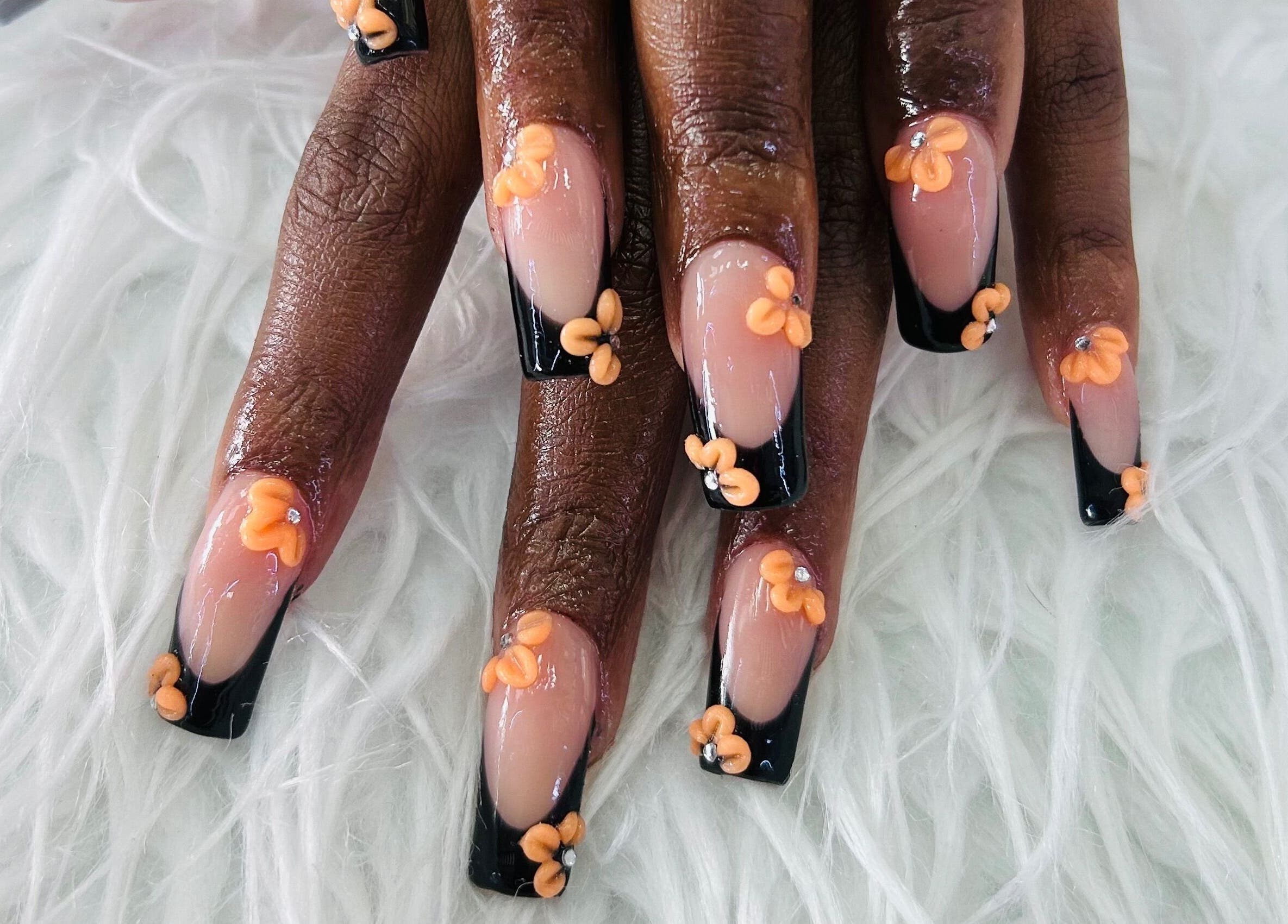 Stylish floral nail art at Essentials by L.T, Midrand, Gauteng, ZA featuring orange flowers on black tips.