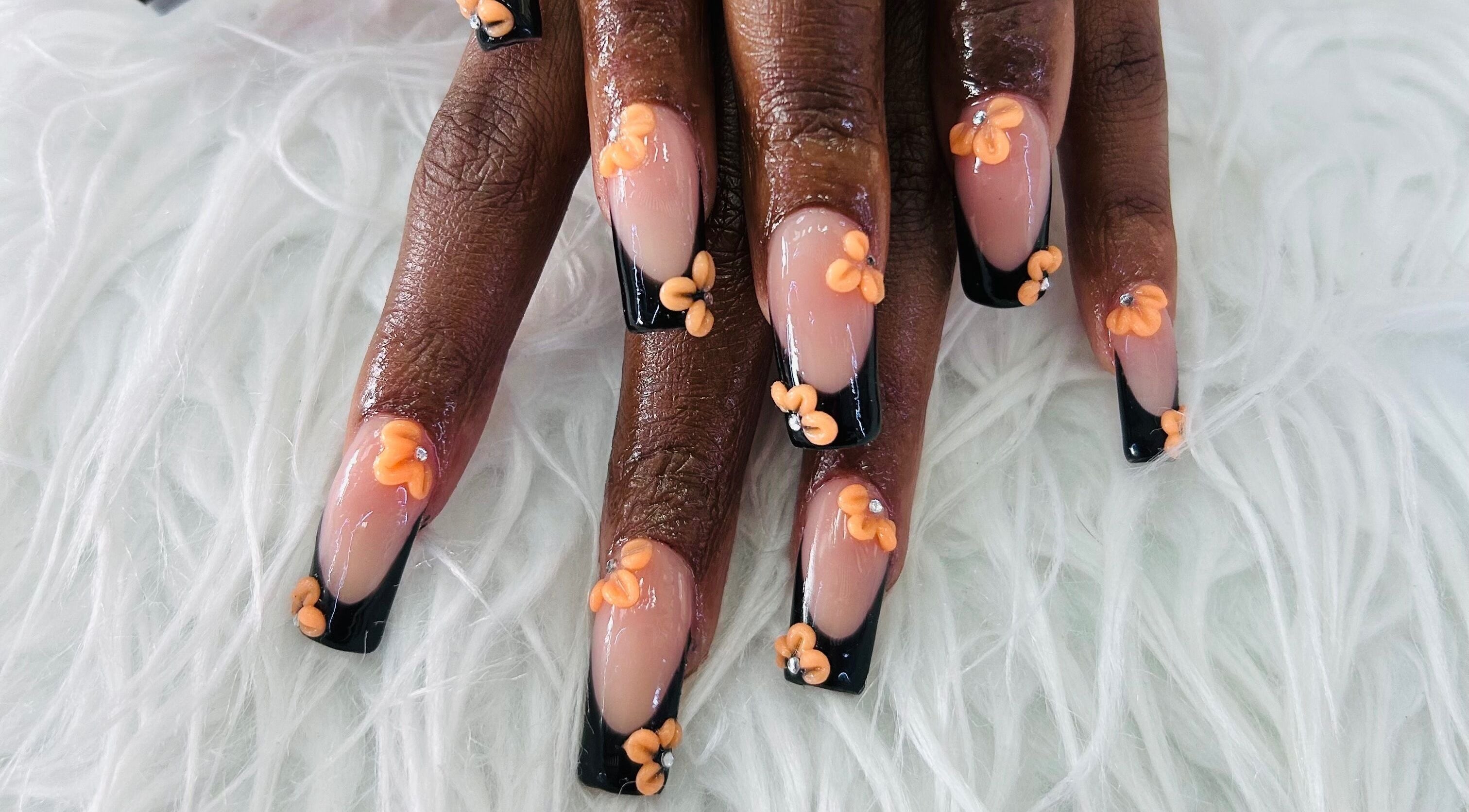Stylish floral nail art at Essentials by L.T, Midrand, Gauteng, ZA featuring orange flowers on black tips.