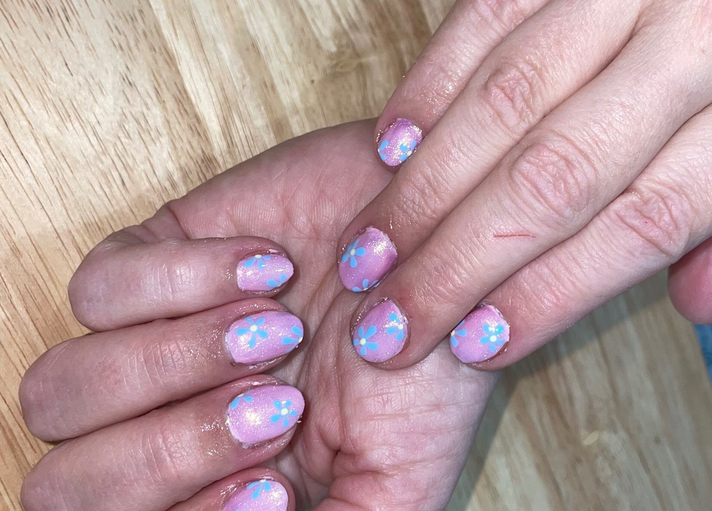 Pastel nails with blue flowers at Jeweled by Jules in Ottawa, Ontario, CA, showcasing intricate nail art.