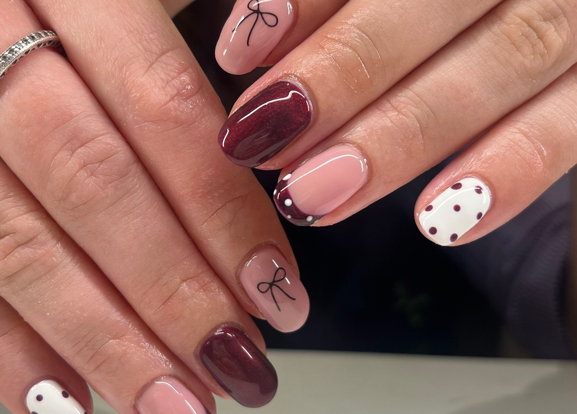 Elegant manicure featuring polka dots and ribbon design at The Beauty Shed, West, England, GB.